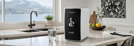 EDEL WASSER countertop water purifier in a modern NZ kitchen beside a clear glass of filtered water